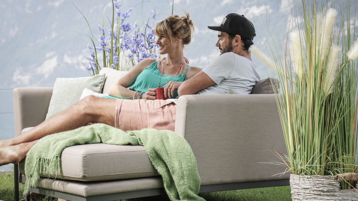 Ein Mann und eine Frau sitzen auf einer wetterfesten Gartenlounge